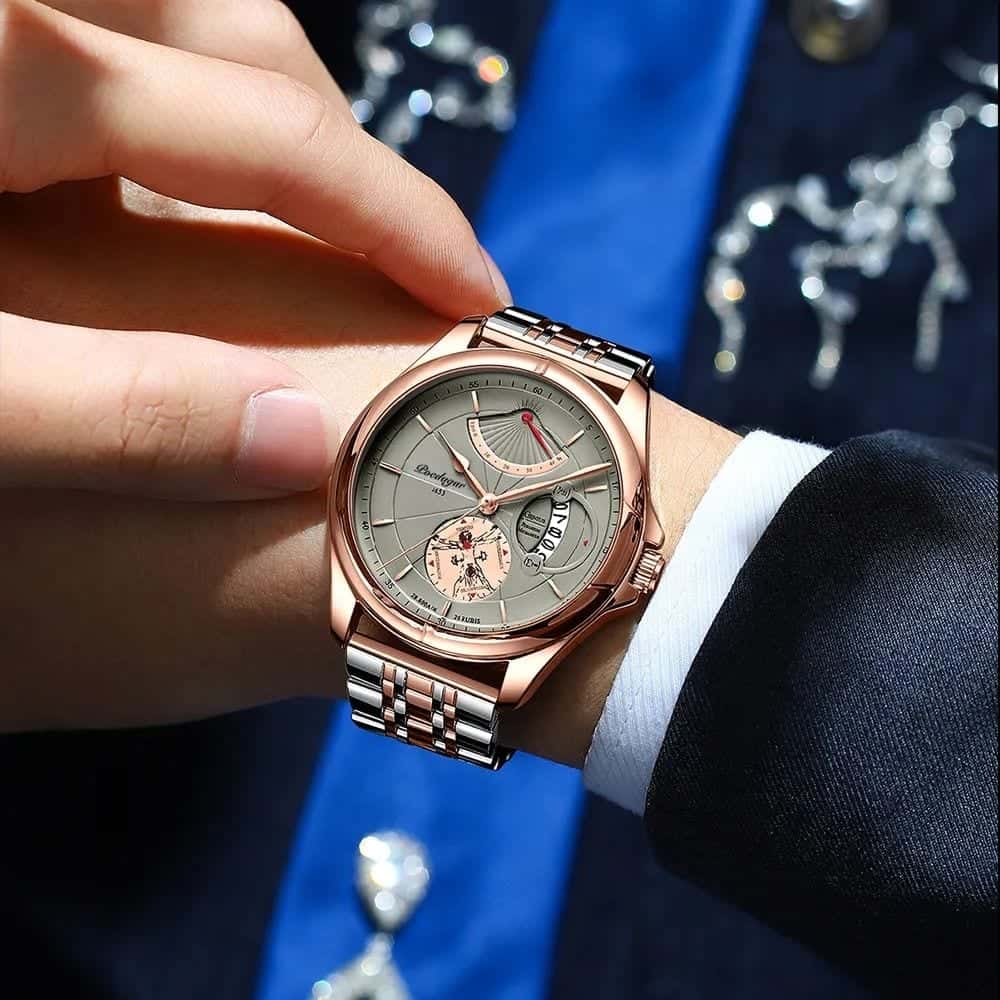 The watch on the wrist of a man in a suit and blue tie